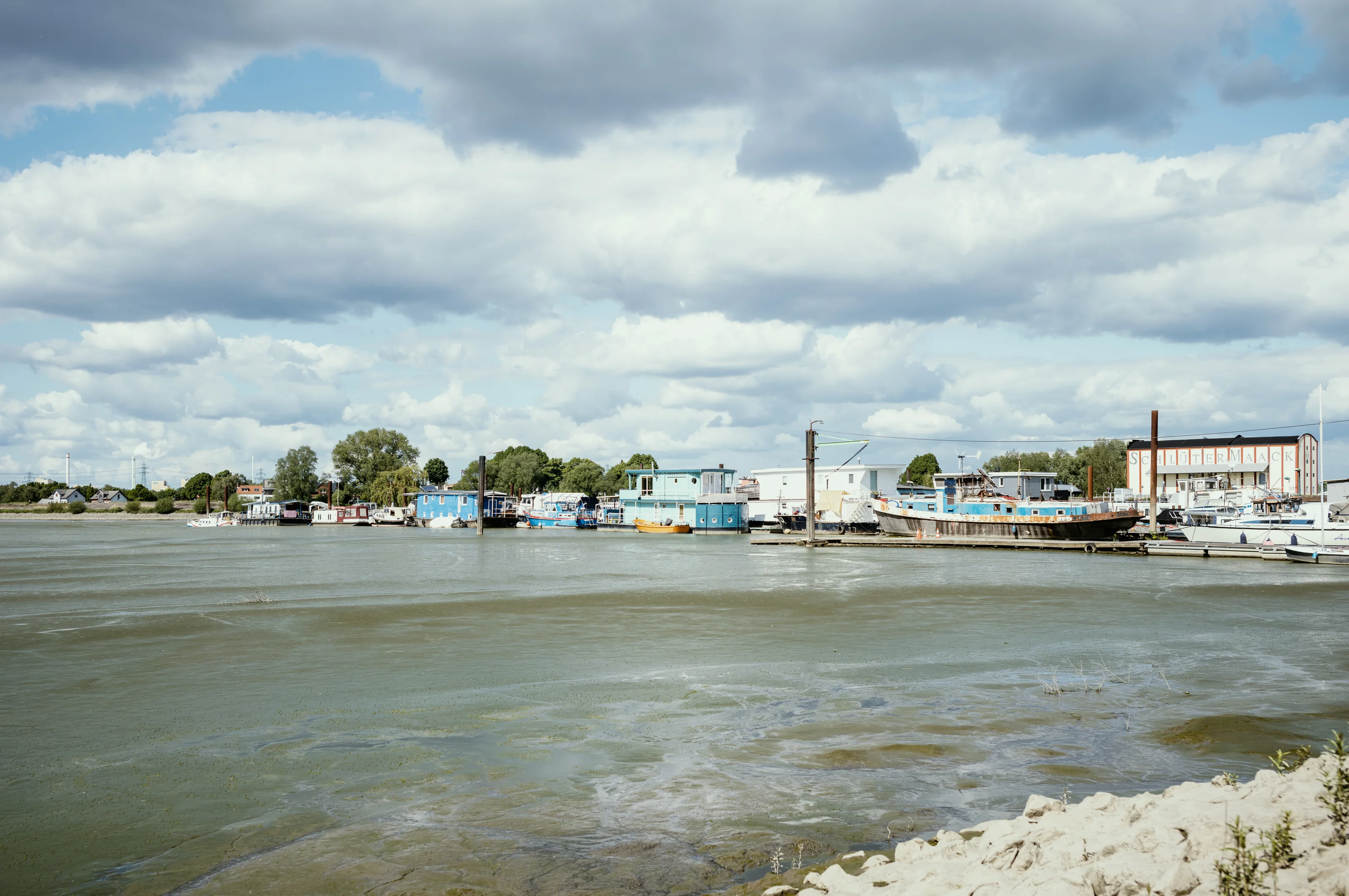 A small harbor with boats docked under a cloudy sky.