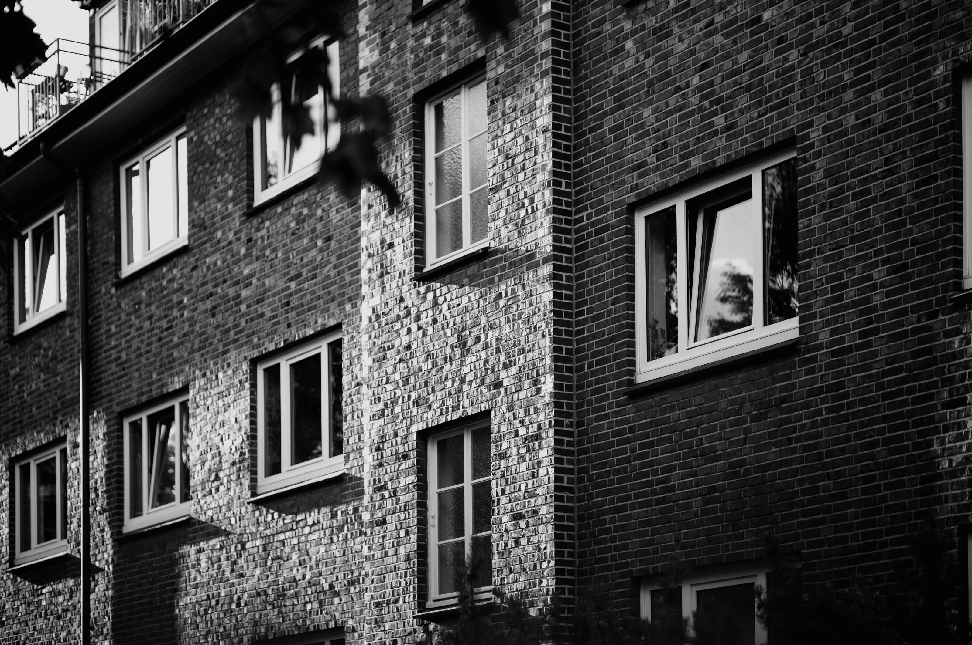 Black and white photo of a brick building with several windows.