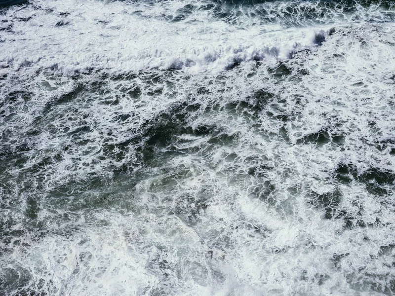 Waves crashing in the ocean with foamy water.